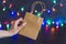 Festive season shopping concept bag with multicolour Christmas string lights bokeh