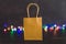 Festive season shopping concept bag with multicolour Christmas string lights bokeh