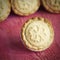 Festive shortcrust pastry mince pies. A sweet mince pie, a traditional rich festive food on red wooden background.