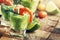 Festive snack, shrimp and avocado sauce in shot glass, old wooden background, selective focus