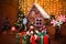 Festive snowman on background of blurred Christmas interior with wooden house, candy, tree and gifts. No people. Holiday