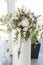 Festive stand with magnificent bouquet of fresh flowers in white banquet hall closeup. Floral composition, decorated