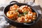 Festive sticky chicken thighs with apricot glaze and almond flakes close-up in a frying pan. horizontal