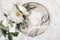 Festive summer wedding scene. Marble table setting with cutlery, olive branches, white peony flowers, stoneware plate