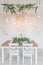 Festive table decorated with garland of branches eucalyptus on the center and candles. Decor christmas table retro garlands. The