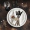 Festive table place setting. Crockery and cutlery on a dark textured background with copy space. Christmas Xmas New Year holiday