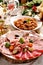 Festive table with a platter of sliced ham and cured meats and sauerkraut stew for Christmas