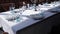 Festive table set with white cloth, plates, forks blue glasses and candlestick with white candles for wedding, family event or
