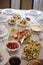 Festive table setting with elegant cutlery and crockery and hand-painted plates with meat plate, eggs and bread for Easter dining