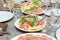 Festive table setting, family dinner with served italian antipasti - marinated salmon, hamon, Carpaccio, pear, basil. Tablescape