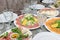 Festive table setting, family dinner with served italian antipasti - marinated salmon, hamon, Carpaccio, pear, basil. Tablescape
