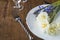 Festive table setting with forged fork and knife and bouquet of daffodils and hyacinths flowers on white plate