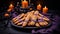 Festive wooden black table with plate of sweet witch\\\'s fingers cookies purple decor and candles