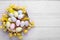 Festively decorated Easter eggs on white wooden table, top view. Space for text