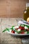 Feta arugula salad with tomatoes on white plate, summer food