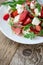 Feta arugula salad with tomatoes on white plate, summer food