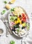 Feta, orzo, tomatoes, cucumbers, radishes, olives, peppers salad on a light background, top view. Healthy food concept. Mediterran