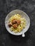 Fettuccine pasta with chicken teriyaki meatballs on a dark background, top view