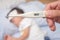 Fever, Close-up medical thermometer, Parent / Father measuring temperature of his ill kid, Asian 3 - 4 years old toddler boy gets