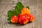 Few berries of cloudberries with a leaf on an old wooden board close-up