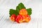 Few berries of cloudberries with a leaf on an white wooden board close-up