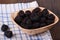 A few blackberries in a wooden bowl. Blackberry on a kitchen towel on a wooden table