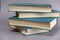 A few books in blue cover against a gray background. A group of hardcover books. Close-up