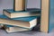 A few books in blue cover against a gray background. A group of hardcover books. Close-up