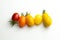 Few cherry tomatoes in a row for color nuance on white background