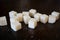 A few cubes of white crystalline refined sugar on a dark old background