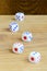 A few dice lies on the surface of natural wood. Items for generating numbers from one to six in the form of points that are paint