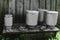 Few Drying Washed Metal Milk Canisters, Churns in the Countryside