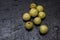 Few fresh organic gooseberries on a black background with selective focus