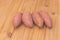 A few fresh sweet potatoes on wooden background - Benefits of sweet potatoes concept