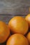 A few oranges, bright orange color on the old wooden background, brown color with a blurred background. Close-up.