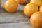 A few oranges, bright orange color on the old wooden background, brown color with a blurred background. Close-up.