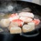 A few pieces of deep-sea scallop and several pieces of crab meat are fried in a pan