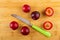 Few plums, knife, halves of plum on bamboo table. Top view