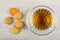 Few small biscuits, cup with tea on saucer on wooden table. Top view