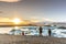 Few tourists dressing cold clothes seeing the amazing sunset at the Jokulsarlon, iceberg lagoon in Iceland