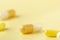 A few white-yellow drug capsules on the yellow background