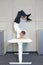Fexible business man in scorpion asana on electric height adjustable desk
