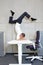 Fexible business man in scorpion asana on electric height adjustable desk