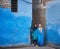 Fez, Morocco - December 07, 2018: couple of Moroccan women leaving a blue alley in the medina of fez