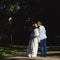 Fiance kisses bride in the ray of sunlight while walking