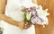 Fiancee in a beautiful white dress holding a beautiful bouquet of wedding flowers made of tender roses and lilies in hand