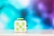 Fidget cube anti stress toy. Detail of finger play toy used for relax. Gadget placed on colorful bokeh background