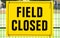 FIELD CLOSED sign attached to a fence