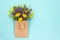 Field colorful rustic flowers in craft package on blue background. Greeting card Flat Lay Copy space Concept Hello spring or Hello