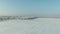 The field covered with snow in a winter season. Winter landscape of countryside, forest, field, trees covered with snow.